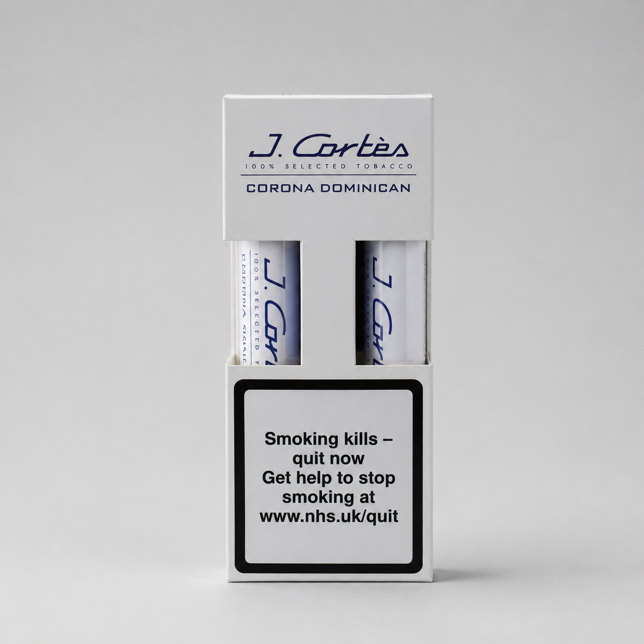 A white J. Cortés Corona Dominican tobacco packaging box on a light gray background, showing two rolled tobacco papers and a prominent smoking-health warning label on the front.