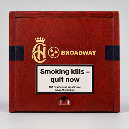 A rectangular wooden box with a reddish-brown woodgrain finish, featuring gold and black branding that reads 'AH' with a crown and 'BROADWAY'. A large white warning label on the front reads 'Smoking kills - quit now' with smaller smoking-cessation text below.