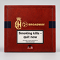A rectangular wooden box with a reddish-brown woodgrain finish, featuring gold and black branding that reads 'AH' with a crown and 'BROADWAY'. A large white warning label on the front reads 'Smoking kills - quit now' with smaller smoking-cessation text below.