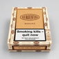A box of Buenaventura Maduro cigarillos, featuring a light wood-grain style front panel with the brand name and a prominent black and white health warning label. The box is shown on a neutral light gray background.