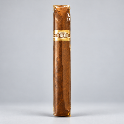 A single brown cigar standing upright, wrapped in clear plastic with a gold band labeled 'Cruelty Free' on a light gray background.