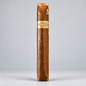 A single brown cigar standing upright, wrapped in clear plastic with a gold band labeled 'Cruelty Free' on a light gray background.