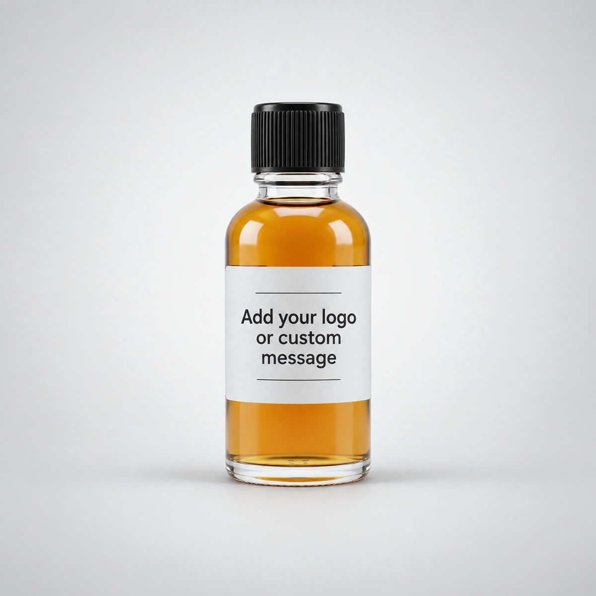 A small clear glass bottle with a black ribbed cap and a white label reading 'Add your logo or custom message,' filled with amber liquid, centered on a light gray background.