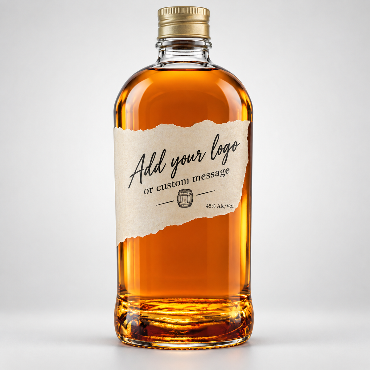 A clear glass bottle of amber liquor with a gold cap and a torn-paper style label reading 'Add your logo or custom message' on a light gray background.