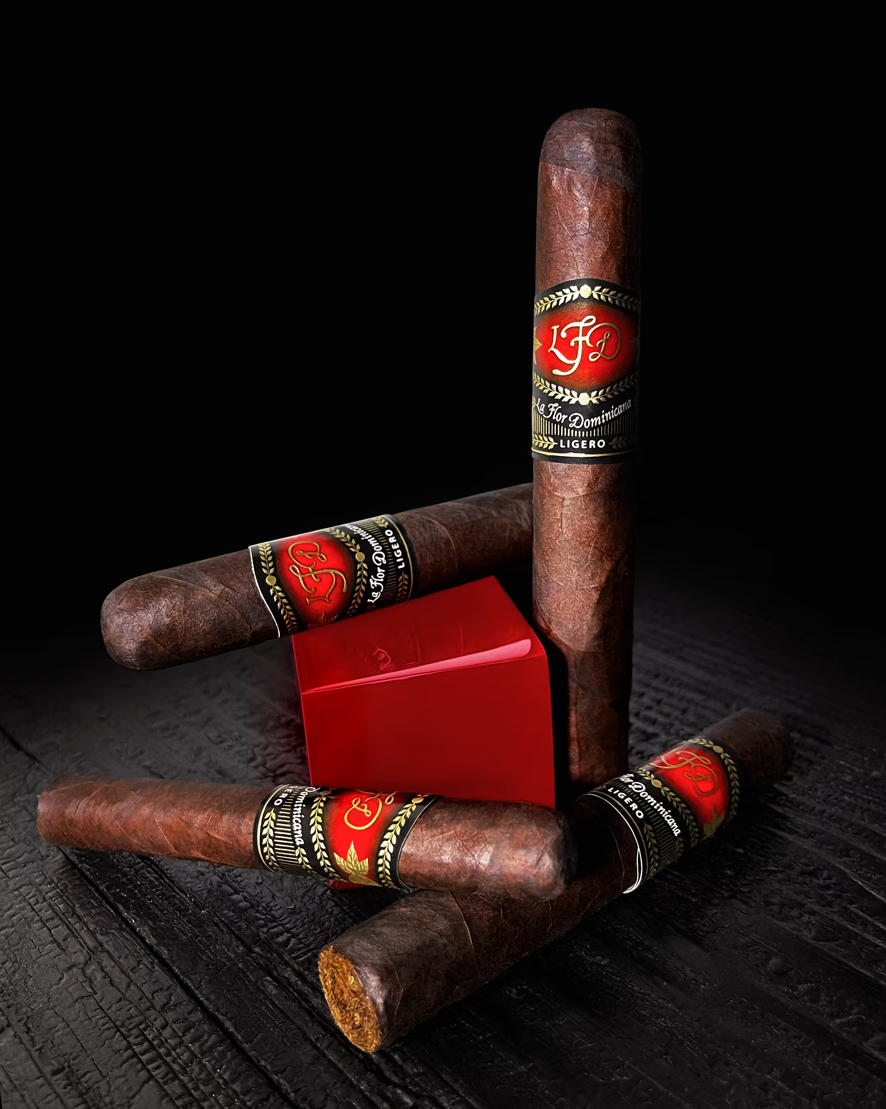 Cigars with visible branding on a dark textured surface