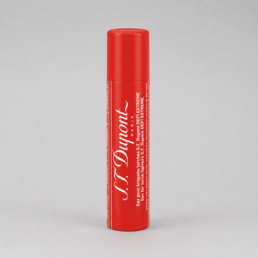 A red cylindrical tube of S.T. Dupont St. Extreme lip balm with white text, standing upright on a light gray background.