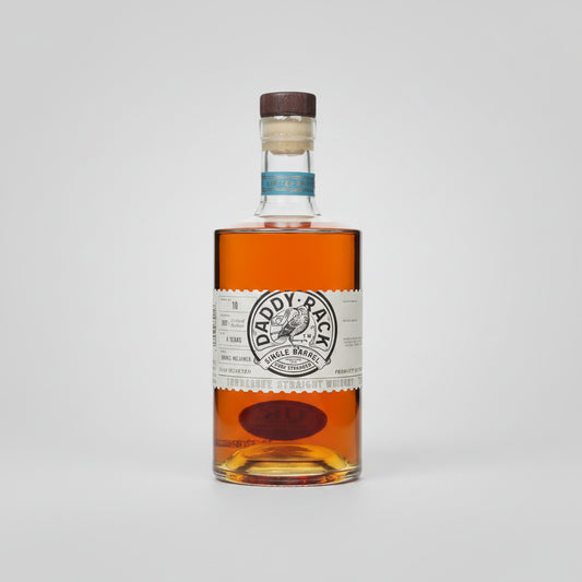 A bottle of Daddy-Rack Single Barrel bourbon whiskey with amber liquid, a white paper label, and a brown cork stopper, shown on a white background with a soft reflection.