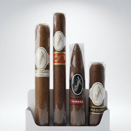 Four Davidoff cigars in a white plastic display stand against a light gray studio background. The cigars are wrapped in brown paper with white, red, and black labels, including visible text such as Anniversary, Yamasa, and Maduro.