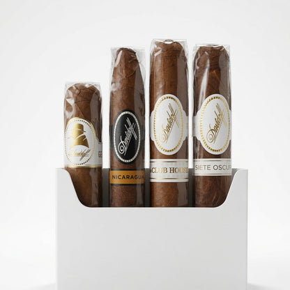 Four cigars in clear plastic wrappers displayed upright in a white rectangular box on a clean white background. The cigars have brown to medium-brown tobaccos with white, black, and gold labels featuring the brand name 'Siete Oscuro'.