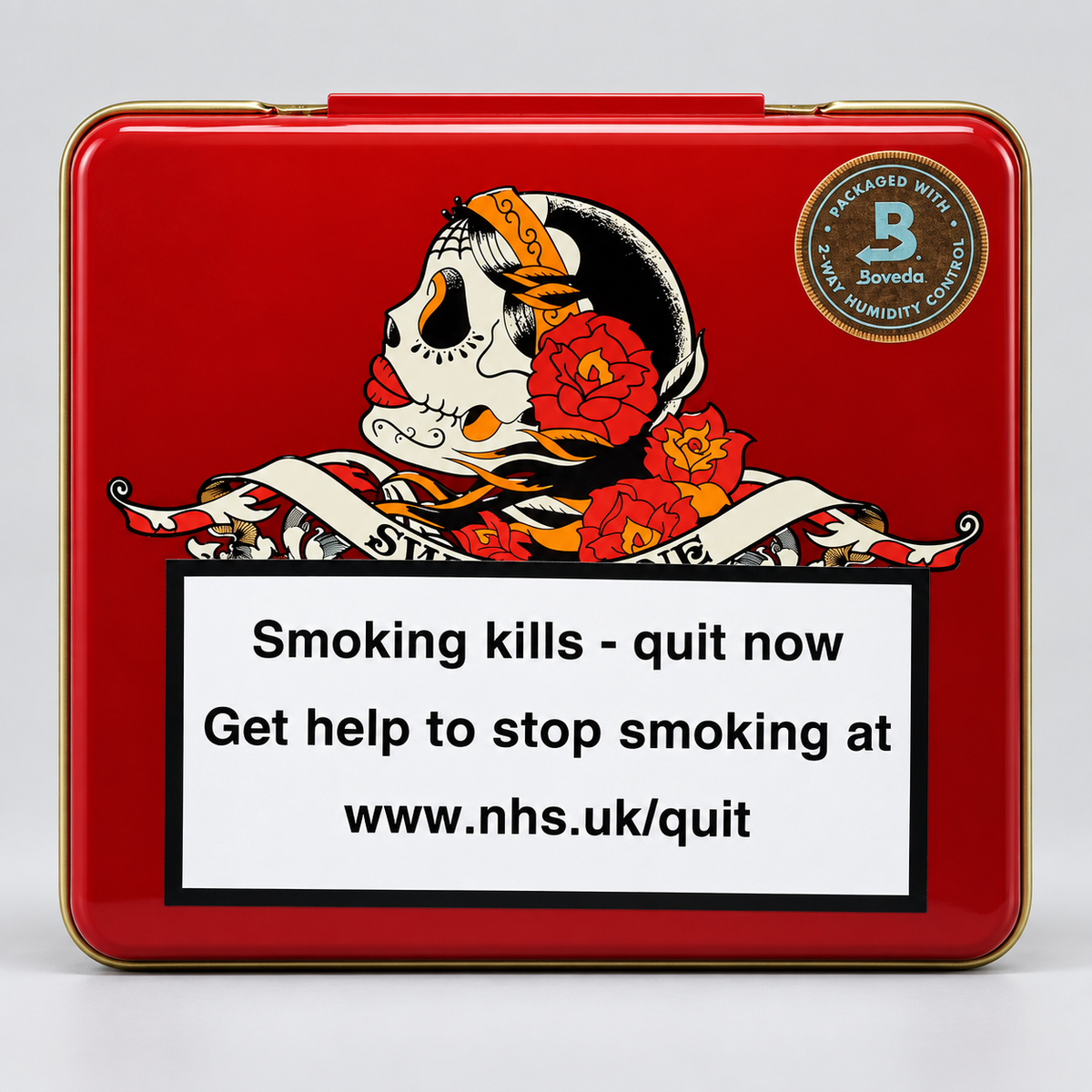 A square red metal tin with a gold-toned rim, featuring a Day of the Dead style skull and red flowers on the front, plus a large smoking-health warning label and a circular 'Sovedo' brand mark. The tin is photographed on a light gray studio background.