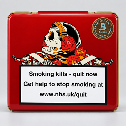 A square red metal tin with a gold-toned rim, featuring a Day of the Dead style skull and red flowers on the front, plus a large smoking-health warning label and a circular 'Sovedo' brand mark. The tin is photographed on a light gray studio background.