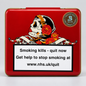A square red metal tin with a gold-toned rim, featuring a Day of the Dead style skull and red flowers on the front, plus a large smoking-health warning label and a circular 'Sovedo' brand mark. The tin is photographed on a light gray studio background.