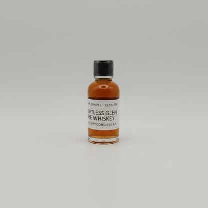 Small bottle of Diftless glen Whiskey on a light gray background