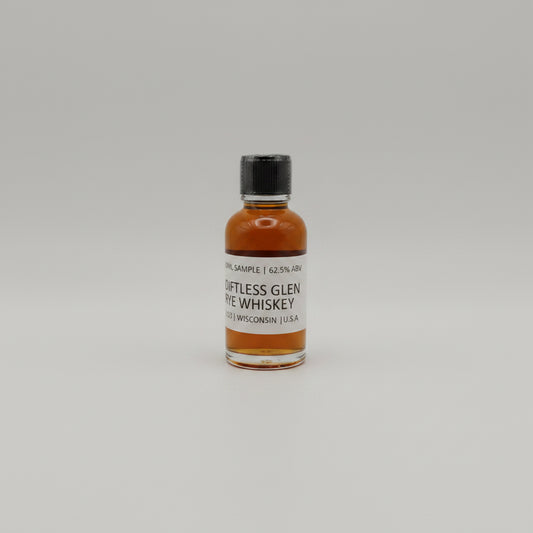 Small bottle of Diftless glen Whiskey on a light gray background