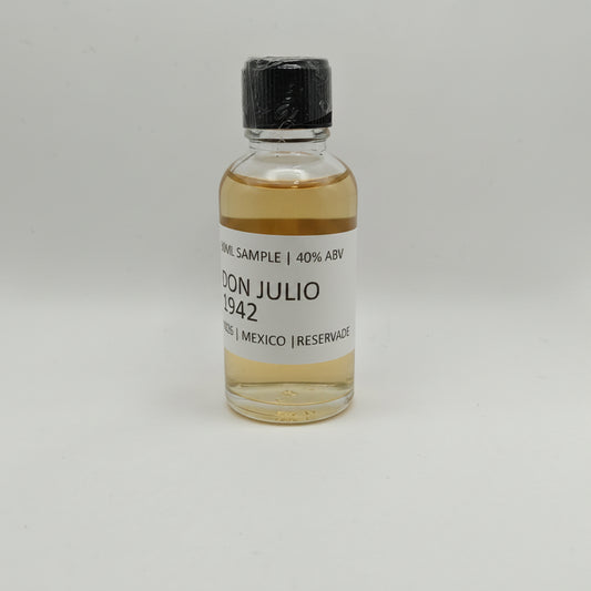 Small bottle of Don Julio 1942 on a gray background