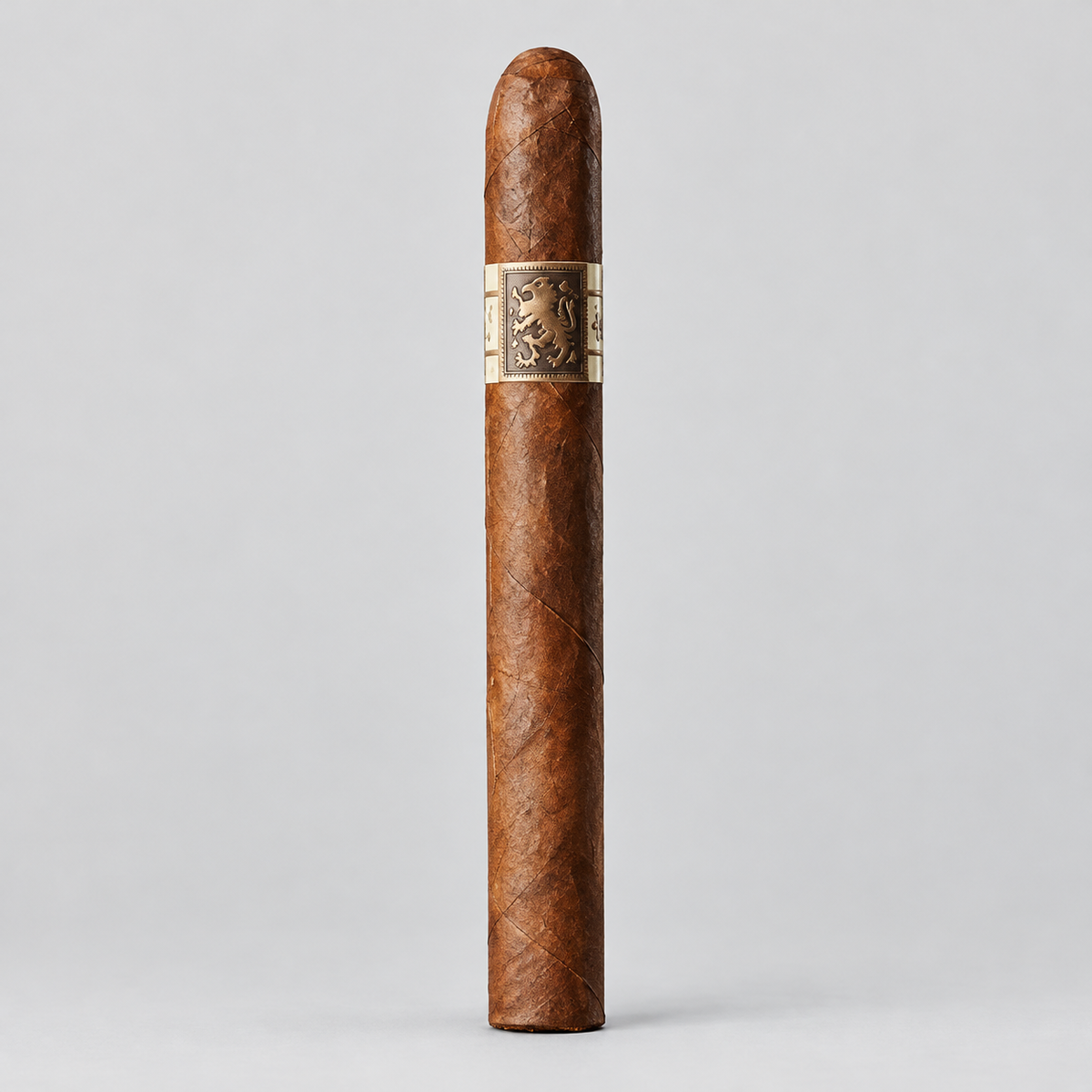 A single brown cigar standing upright against a light gray studio background, with a beige band featuring a dark crest logo around the middle.