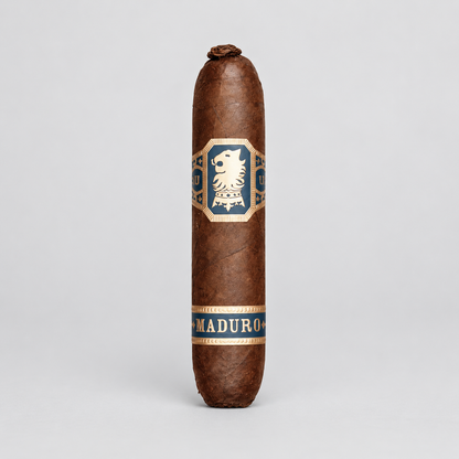A single brown cigar standing upright on a light gray studio background, featuring a central blue and gold label with a lion emblem and the word 'MADURO' near the bottom.