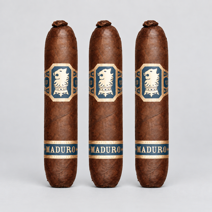 Three brown cigars standing upright against a light gray background, each with a blue and gold label featuring a white lion emblem and the word MADURO.
