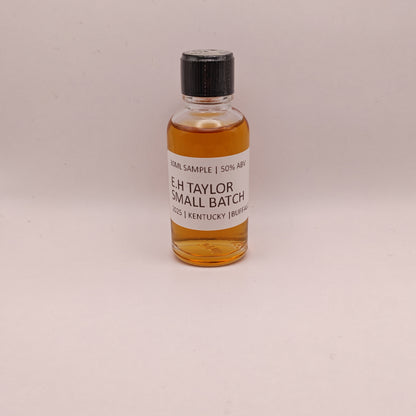 Small bottle of E.H. Taylor Small Batch whiskey on a beige background
