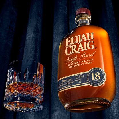 Bottle of Elijah Craig 18-year-old bourbon with a glass of whiskey on a dark background
