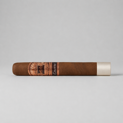 A single brown cigar shown horizontally against a light gray background, featuring a decorative copper-toned band with the brand name 'Habanos' and the model name 'Encore' in black script, finished with a white tip.