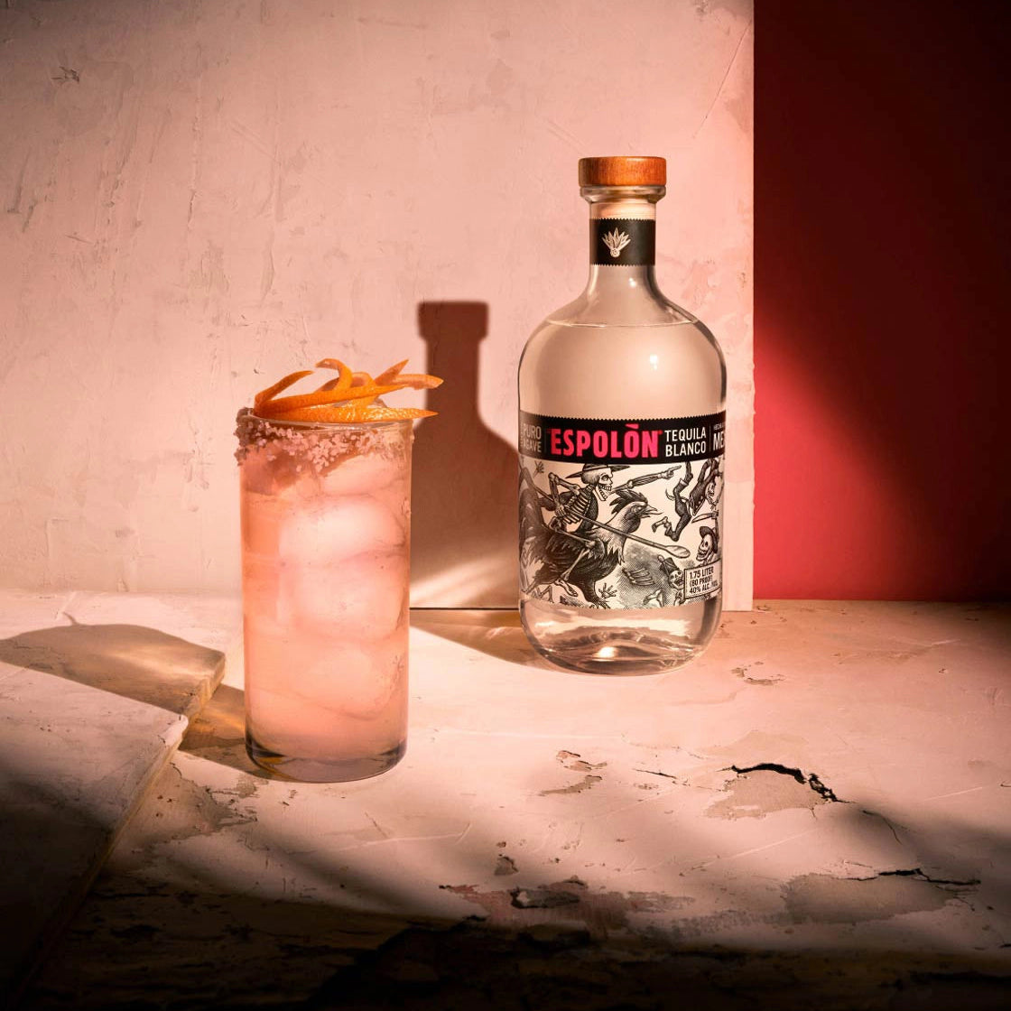 Espolón tequila bottle with a cocktail on a textured surface