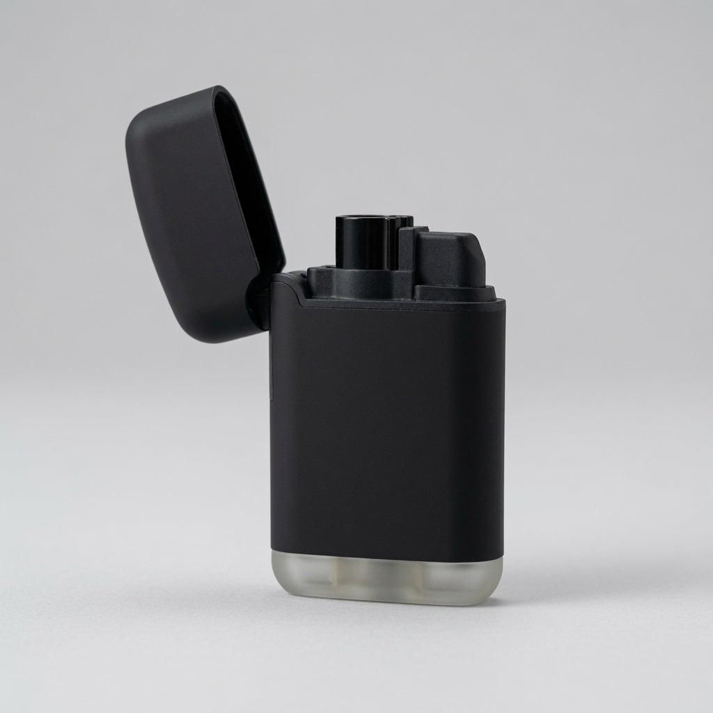 A matte black electronic lighter with its lid open, standing on a light gray surface against a neutral gray background.