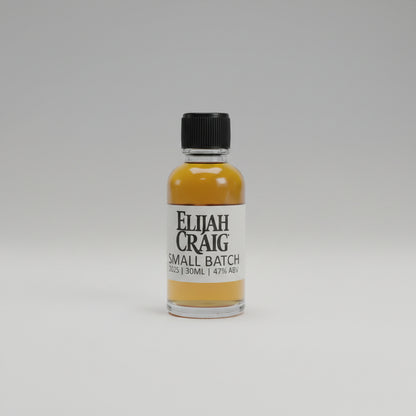 Bottle of Elijah Craig small batch whiskey on a table with a blurred background