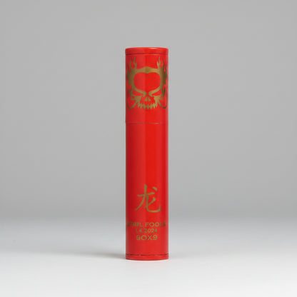 A red cylindrical cigat tube product,, decorated with gold foil graphics including a dragon motif, a Chinese character for dragon, and vertical text reading 'APRIL FOOLS 2024' and 'BOX 9'.
