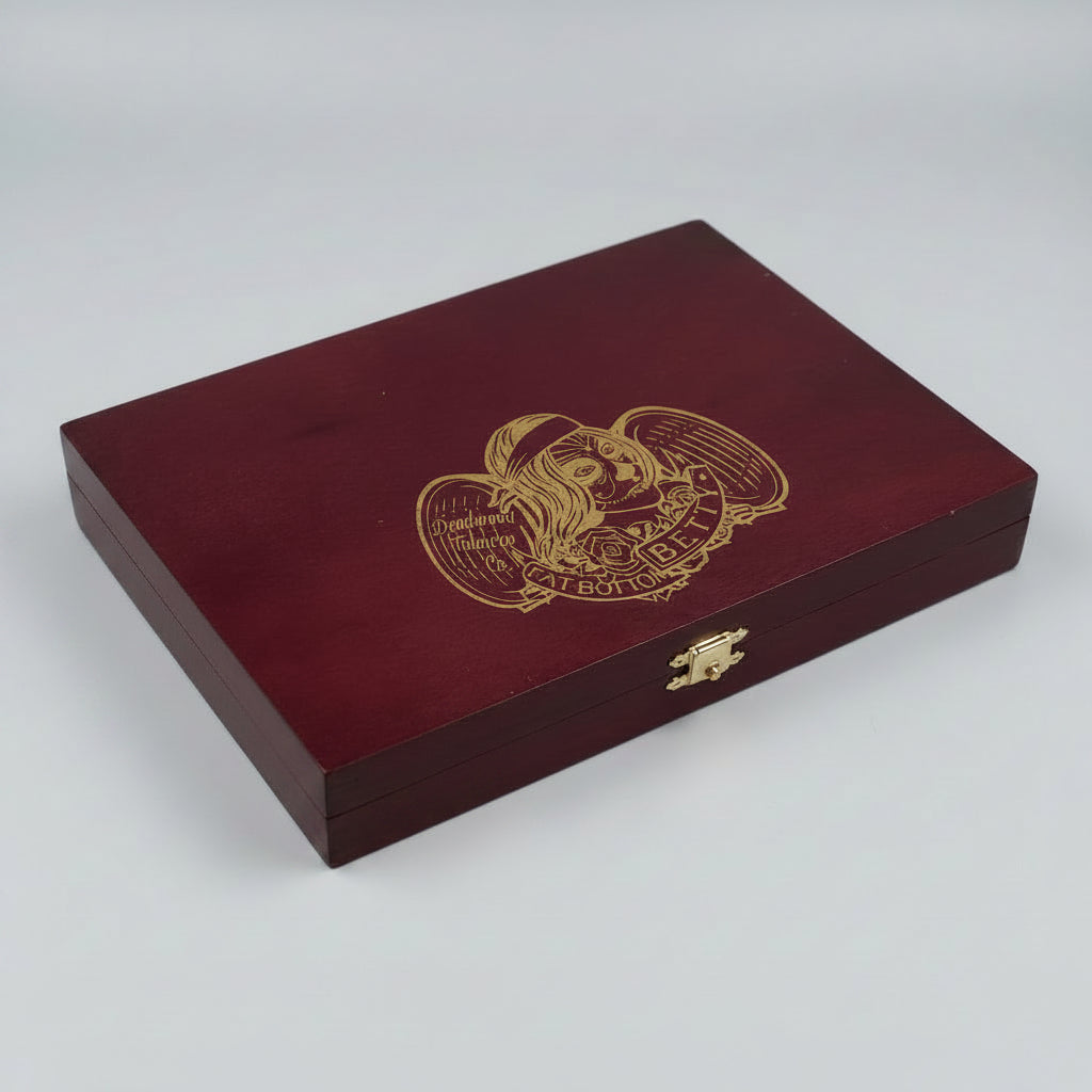 A rectangular dark red wooden presentation box with a gold engraved illustration of a winged skull and the text 'Viva BF 101' on the lid, photographed on a light gray background.
