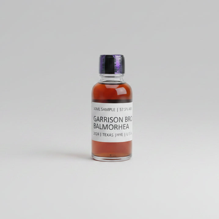 Bottle of Garrison Brothers Balmorhea whiskey on a reflective surface with blurred background