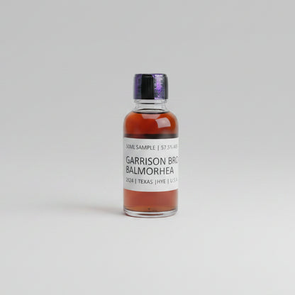 Bottle of Garrison Brothers Balmorhea whiskey on a reflective surface with blurred background