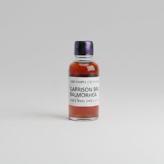Bottle of Garrison Brothers Balmorhea whiskey on a reflective surface with blurred background