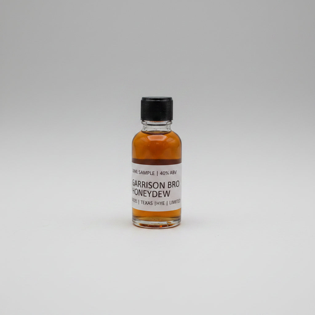 Small bottle of Garrison Brothers Honeydew on a beige background