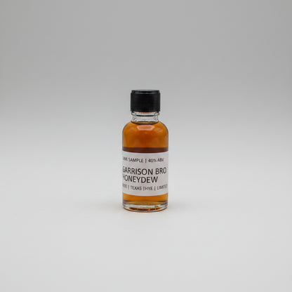 Small bottle of Garrison Brothers Honeydew on a beige background