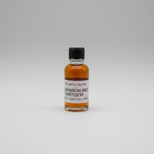 Small bottle of Garrison Brothers Honeydew on a beige background