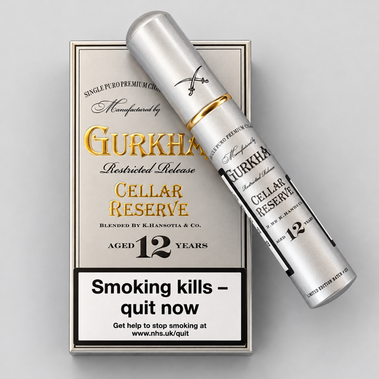 A silver Gurkha Cellar Reserve 12-year-old single pot premium muggler bottle resting diagonally on its matching silver and gold packaging box against a light gray background.
