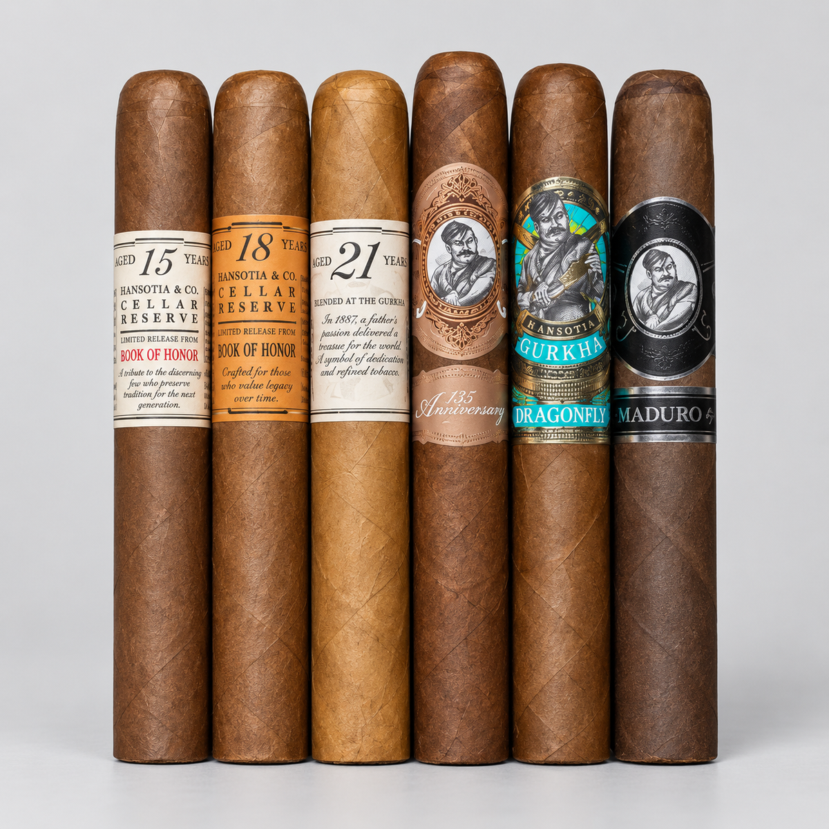 Six cigars standing upright in a row against a light gray studio background, each with a distinct paper band label in different colors and designs.