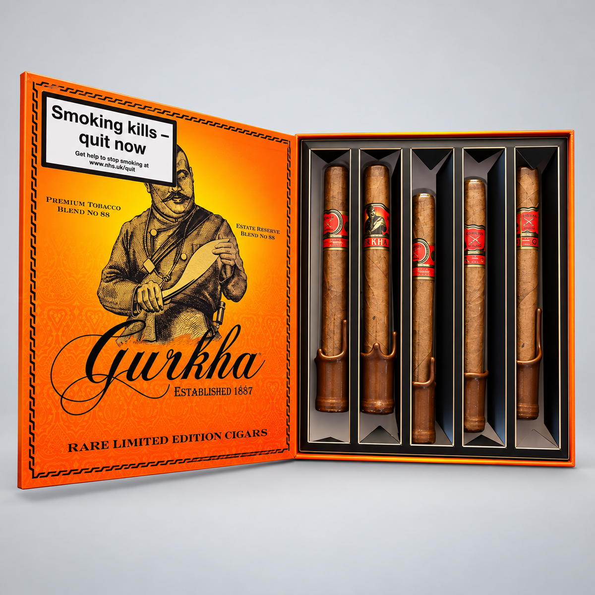 An open orange cigar gift box labeled Gurkha Rare Limited Edition Cigars, showing five cigars inside black slots on the right and illustrated packaging on the left, photographed on a light gray background.