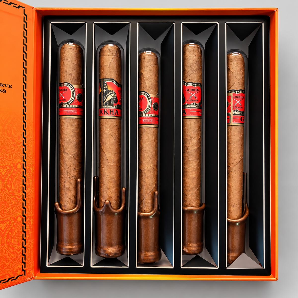 Five cigars arranged vertically inside an orange presentation box with black compartments. Each cigar has a red and black band with the brand name visible, and the box lid is partially open to the left.