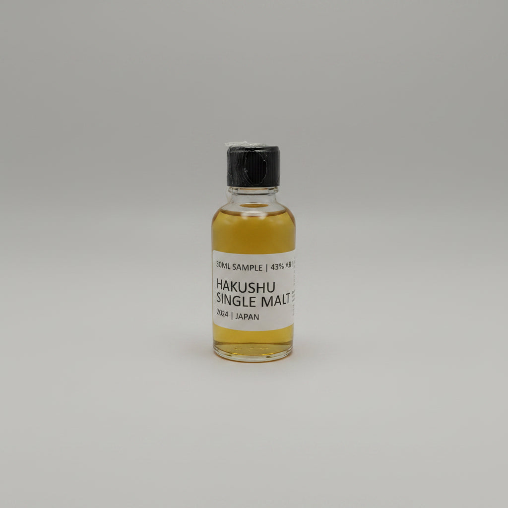 Small bottle of Hakushu Single Malt whisky sample on a gray background