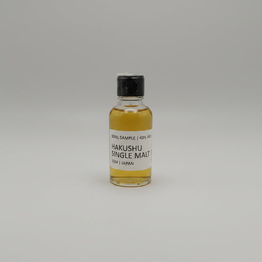 Small bottle of Hakushu Single Malt whisky sample on a gray background