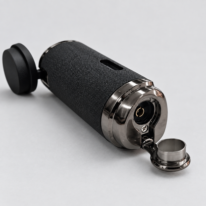 A black cylindrical electronic lighter with a textured grip, polished silver metal accents, and an open flip-up lid, shown on a light gray background.
