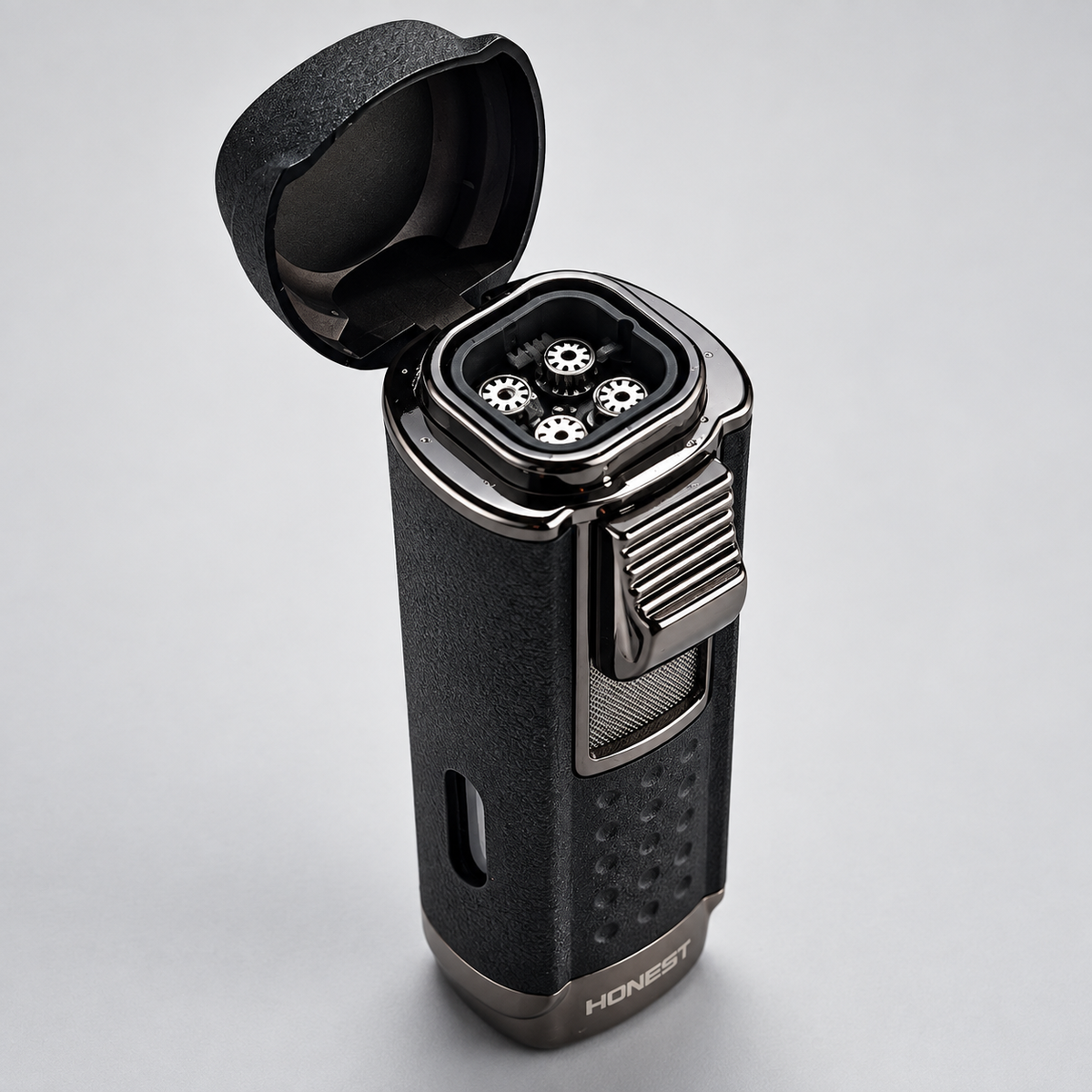 A black electric lighter with its hinged lid open, showing four metallic ignition buttons on top. The lighter has a textured black body with brushed silver metal accents, a textured side grip, and the brand name 'HONEST' printed on the bottom base, set against a neutral light gray background.