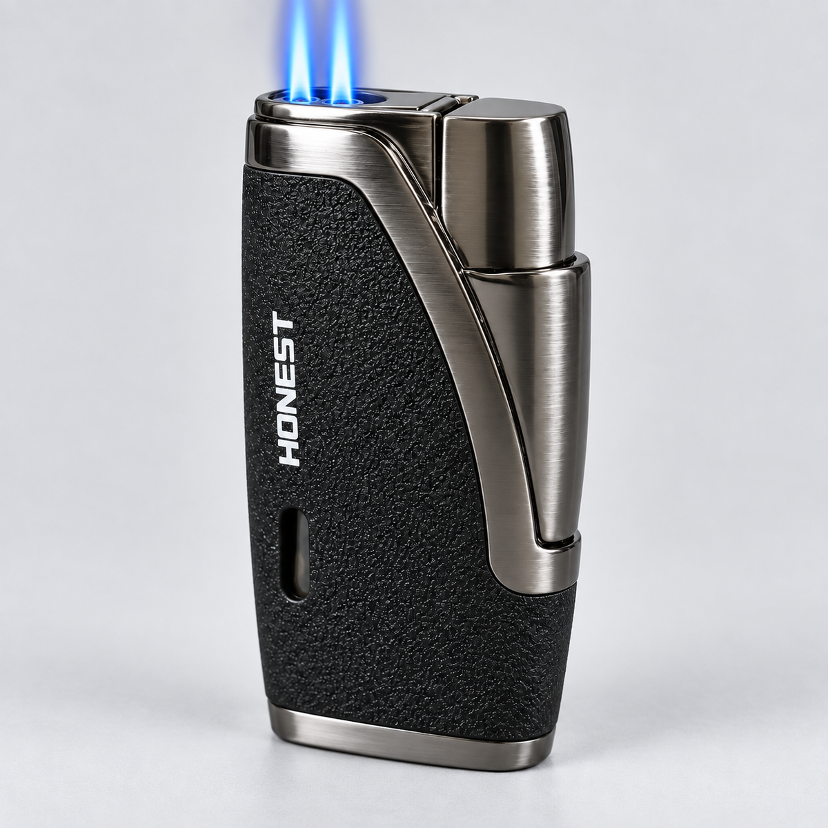 A sleek torch lighter with a black textured grip and brushed silver metal accents, shown lit with a blue flame against a light gray background. The brand name 'HONEST' is printed vertically on the side.