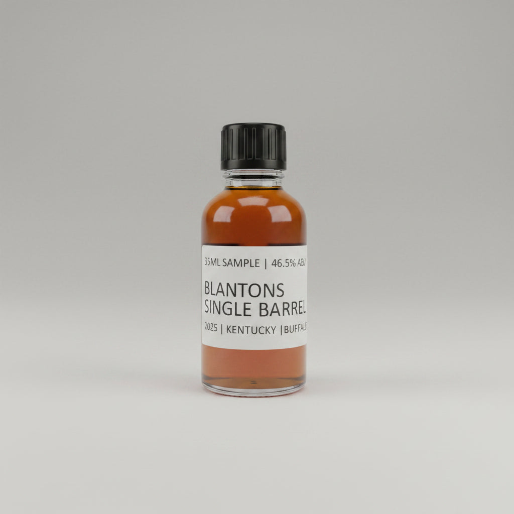 Small bottle of Blanton's Single Barrel whiskey sample on a plain background