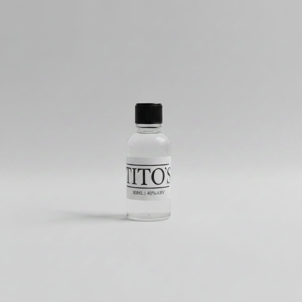 Small bottle 30ml sample of tito's vodka on a white background