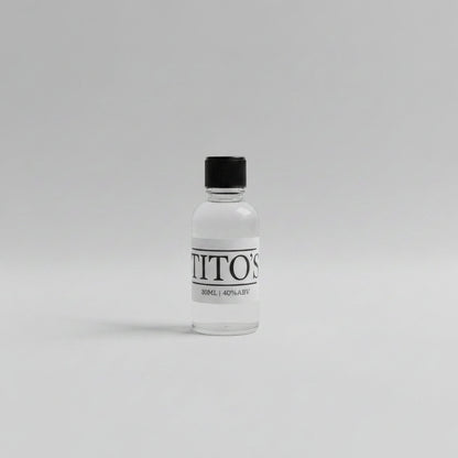 Small bottle 30ml sample of tito's vodka on a white background