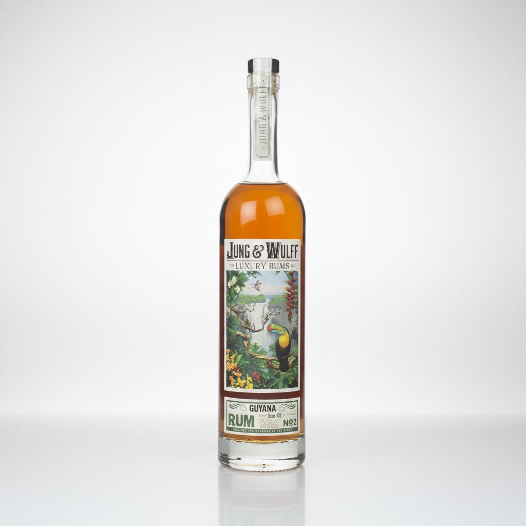 A bottle of Jung & Wulf Luxury Lines Guiana Rum No. 2, featuring amber liquid in a clear glass bottle with a detailed tropical label and a silver foil cap, set against a plain white background.
