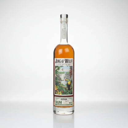 A bottle of Jung & Wulf Luxury Lines Guiana Rum No. 2, featuring amber liquid in a clear glass bottle with a detailed tropical label and a silver foil cap, set against a plain white background.